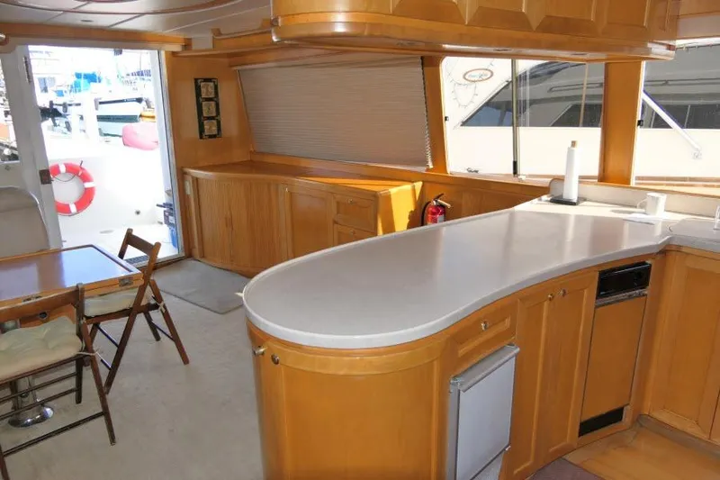 Slide: The Image of Interior of 1999 Hampton 490 Pilothouse yacht with wooden cabinetry and modern amenities. - 8
