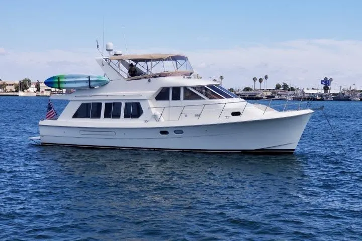 Slide: The Image of 1999 Hampton 490 Pilothouse yacht cruising on calm blue waters. - 88