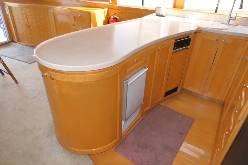 Slide: The Image of Luxurious wooden kitchen interior of 1999 Hampton 490 Pilothouse yacht with curved countertop. - 9