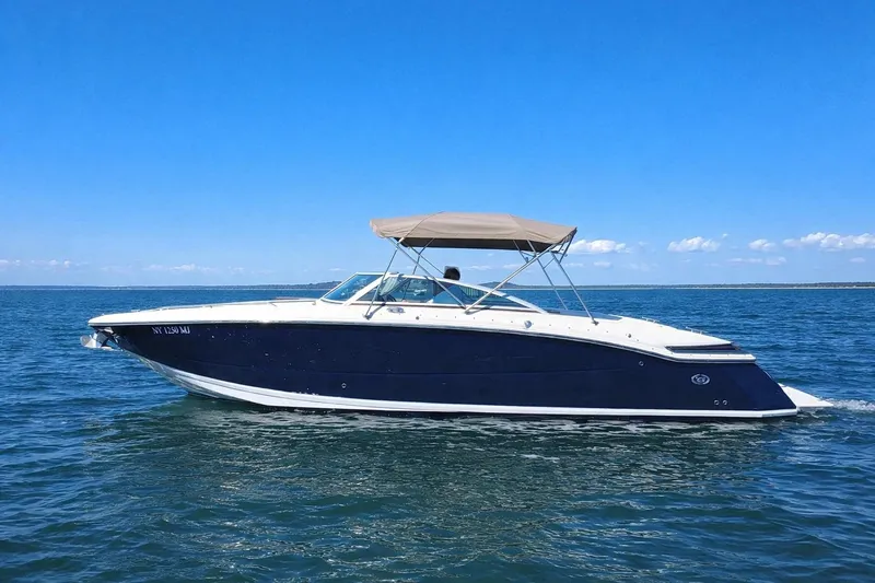 The Image of 2012 Cobalt 296 boat cruising on open water under clear blue skies. - 0