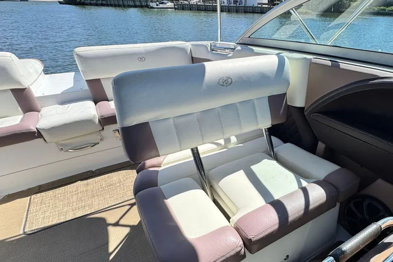 Slide: The Image of Interior of a 2012 Cobalt 296 boat with cushioned seating by the water. - 17