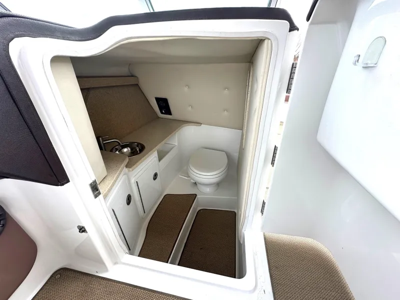 Slide: The Image of 2012 Cobalt 296 boat interior with compact bathroom and sink. - 19