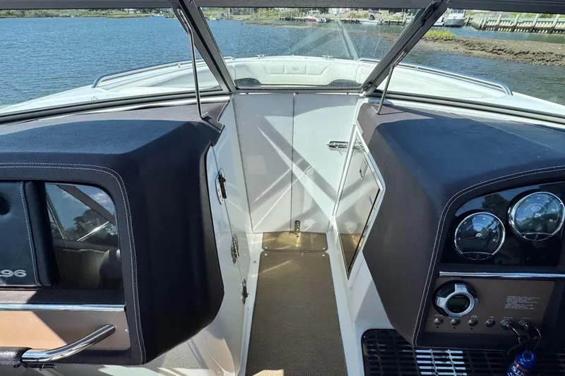 Slide: The Image of Interior view of a 2012 Cobalt 296 boat, featuring dashboard and open cabin door. - 21