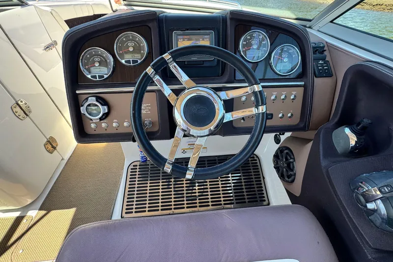 Slide: The Image of Steering wheel and dashboard of 2012 Cobalt 296 boat, featuring gauges and controls. - 25