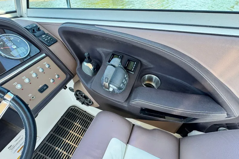 Slide: The Image of 2012 Cobalt 296 boat dashboard with controls, cup holder, and throttle lever. - 26