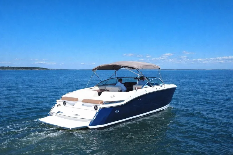 Slide: The Image of 2012 Cobalt 296 boat cruising on open water under clear blue skies. - 3