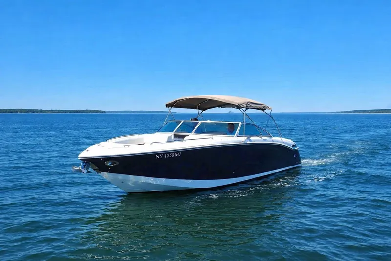 Slide: The Image of 2012 Cobalt 296 boat cruising on a clear blue lake under a sunny sky. - 4