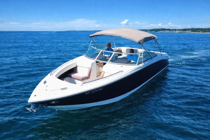 Slide: The Image of 2012 Cobalt 296 boat cruising on open water under clear blue skies. - 6