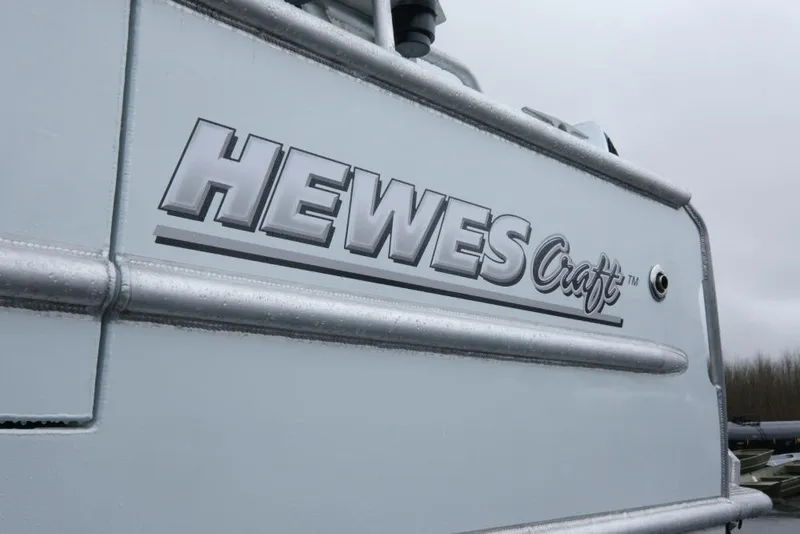 Slide: The Image of 2026 Hewescraft 290 Adventure ET Hardtop boat logo on metallic surface. - 6