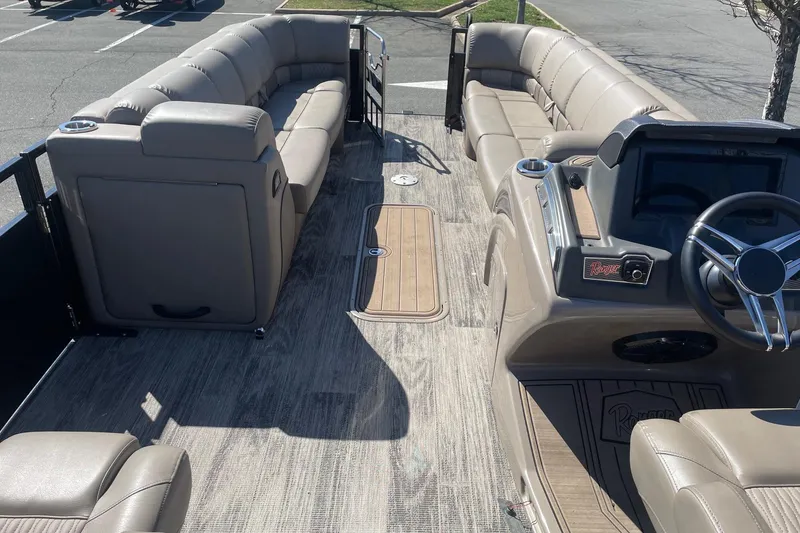 Slide: The Image of 2024 Ranger 2500LS pontoon boat interior with plush seating and modern dashboard. - 14