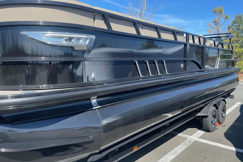 Slide: The Image of 2024 Ranger 2500LS pontoon boat with sleek black exterior on a trailer. - 4