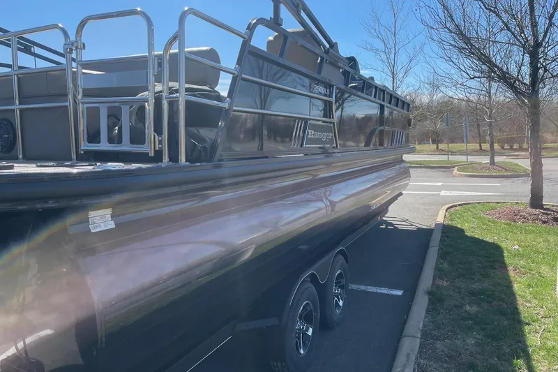 Slide: The Image of 2024 Ranger 2500LS pontoon boat parked outdoors on a sunny day. - 5