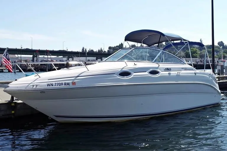 The Image of 2004 Sea Ray 240 Sundancer boat docked at marina with blue canopy. - 1