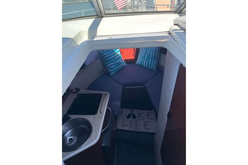 Slide: The Image of Interior of 2004 Sea Ray 240 Sundancer boat with cozy seating and kitchenette. - 11