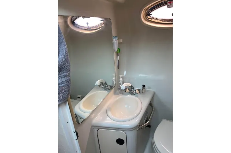 Slide: The Image of Compact bathroom in 2004 Sea Ray 240 Sundancer boat with sink and mirror. - 17