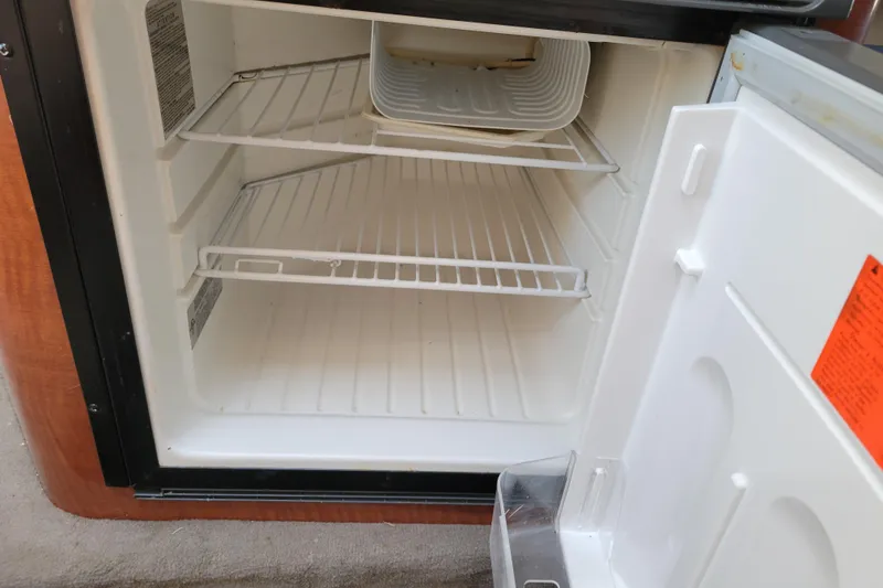 Slide: The Image of Empty refrigerator inside a 2004 Sea Ray 240 Sundancer boat cabin. - 22