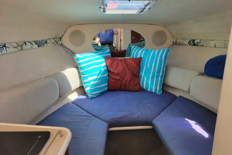Slide: The Image of Cozy cabin interior of 2004 Sea Ray 240 Sundancer with colorful cushions and seating. - 23