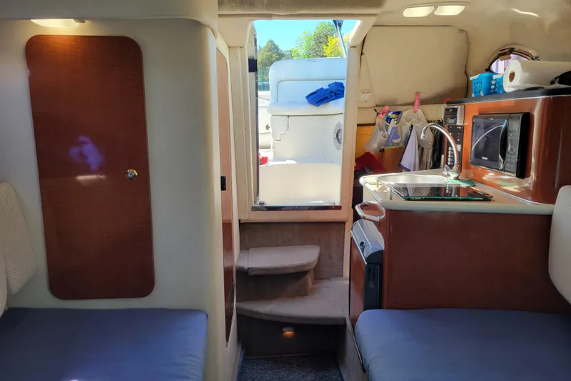 Slide: The Image of Interior of 2004 Sea Ray 240 Sundancer boat with kitchenette and seating area. - 24