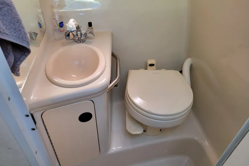Slide: The Image of Compact bathroom in 2004 Sea Ray 240 Sundancer boat with sink and toilet. - 25