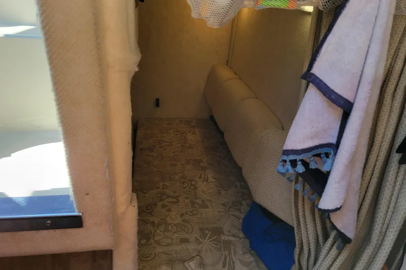 Slide: The Image of Interior cabin of 2004 Sea Ray 240 Sundancer with patterned flooring and hanging towels. - 26