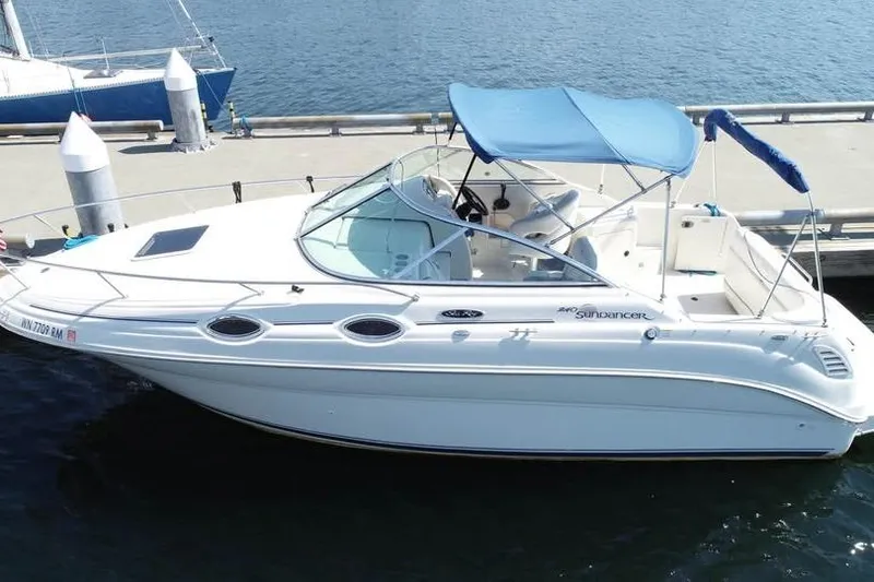 Slide: The Image of 2004 Sea Ray 240 Sundancer boat docked with blue canopy on calm water. - 3