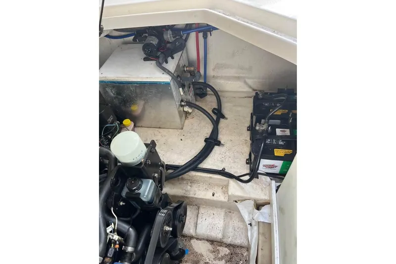 Slide: The Image of Engine compartment of a 2004 Sea Ray 240 Sundancer with visible batteries and wiring. - 30