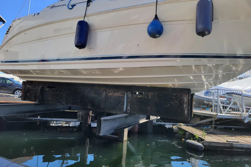 Slide: The Image of 2004 Sea Ray 240 Sundancer boat on lift at marina dockside. - 31