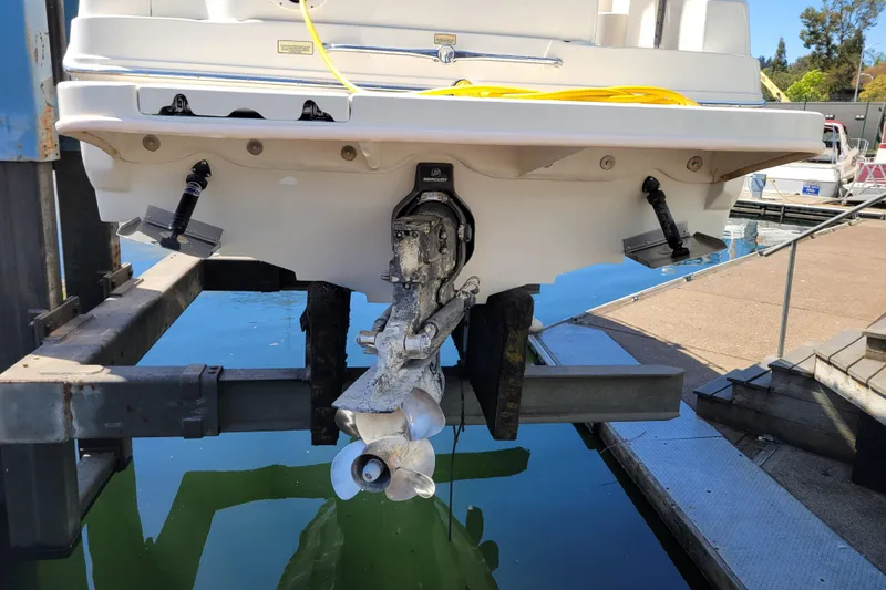 Slide: The Image of 2004 Sea Ray 240 Sundancer boat on lift, showing stern and propeller. - 32