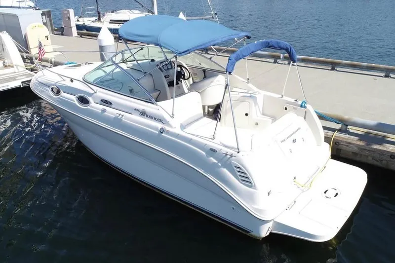 Slide: The Image of 2004 Sea Ray 240 Sundancer boat docked at marina with blue canopy. - 4