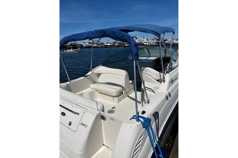 Slide: The Image of 2004 Sea Ray 240 Sundancer boat with blue canopy docked at marina. - 7