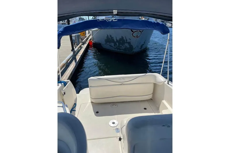 Slide: The Image of 2004 Sea Ray 240 Sundancer boat interior with blue canopy, docked at marina. - 8