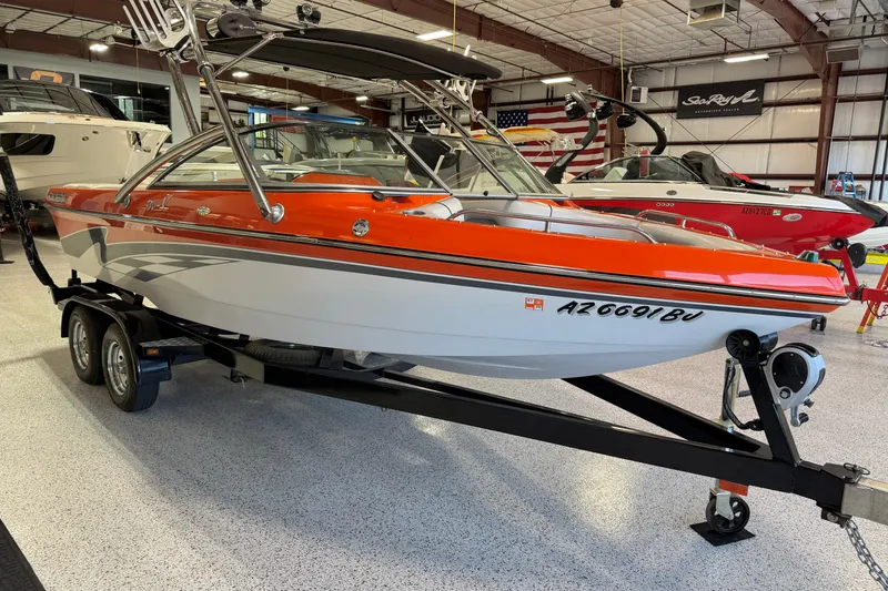 Slide: The Image of 2005 Calabria PRO V boat with orange and white design on a trailer in a showroom. - 11