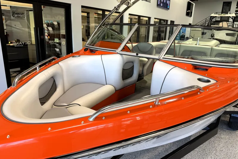 Slide: The Image of 2005 Calabria PRO V boat with orange exterior and white interior, displayed indoors. - 2
