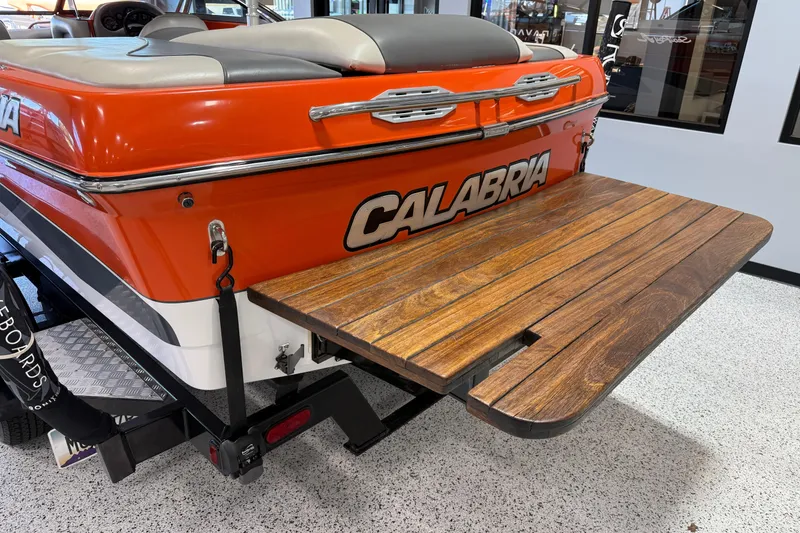 Slide: The Image of 2005 Calabria PRO V boat with orange exterior and wooden swim platform. - 6