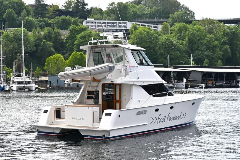 Slide: The Image of 2002 Roger Hill Power Cat 41.4 yacht on a scenic waterfront with lush greenery. - 10