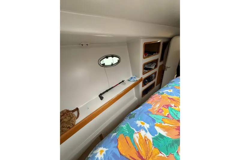 Slide: The Image of Interior of 2002 Norris Custom Motor Catamaran 41.4 with colorful bedding and storage shelves. - 105