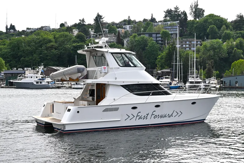 Slide: The Image of 2002 Roger Hill Power Cat 41.4 yacht named "Fast Forward" on a scenic waterfront. - 11