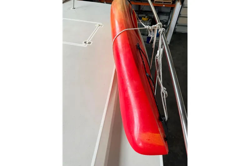 Slide: The Image of Red kayak secured on Norris Custom Motor Catamaran 41.4, 2002 model. - 114