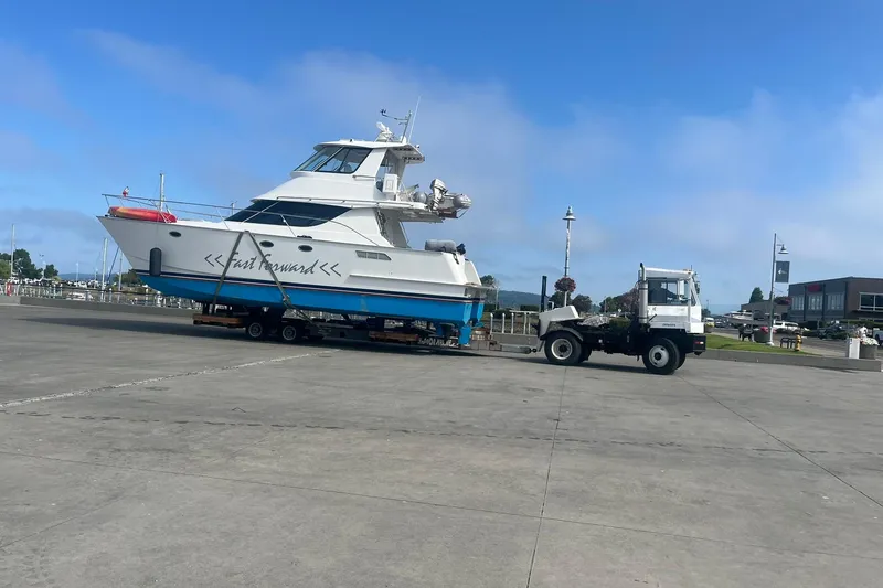 Slide: The Image of Norris Custom Motor Catamaran 41.4, 2002 model, being transported on a trailer at a marina. - 119
