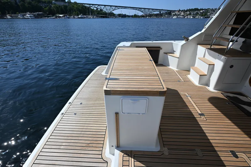 Slide: The Image of Deck of 2002 Roger Hill Power Cat 41.4 with wooden flooring, overlooking serene waters. - 16