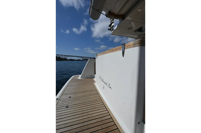 Slide: The Image of Sleek Roger Hill Power Cat 41.4 yacht deck, 2002 model, with scenic water and bridge view. - 19