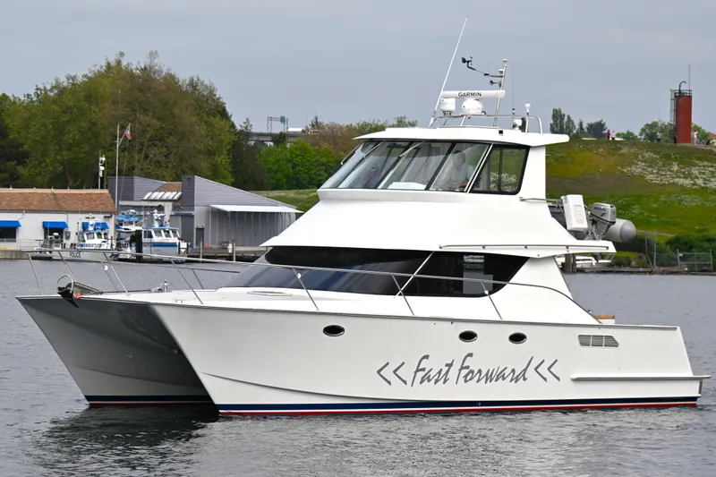 Slide: The Image of 2002 Roger Hill Power Cat 41.4 yacht "Fast Forward" on calm water, dockside view. - 2
