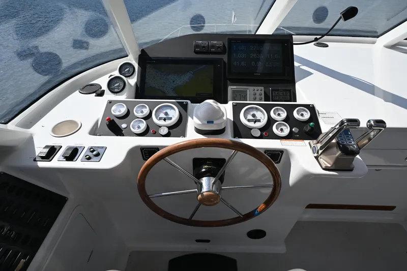 Slide: The Image of Helm of 2002 Roger Hill Power Cat 41.4 with gauges, controls, and wooden steering wheel. - 27