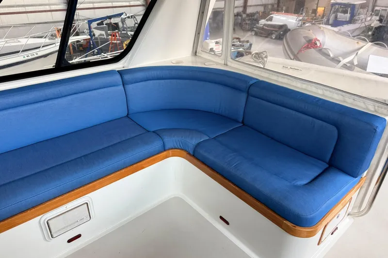 Slide: The Image of Blue cushioned seating inside 2002 Norris Custom Motor Catamaran 41.4, with large windows and wooden trim. - 38