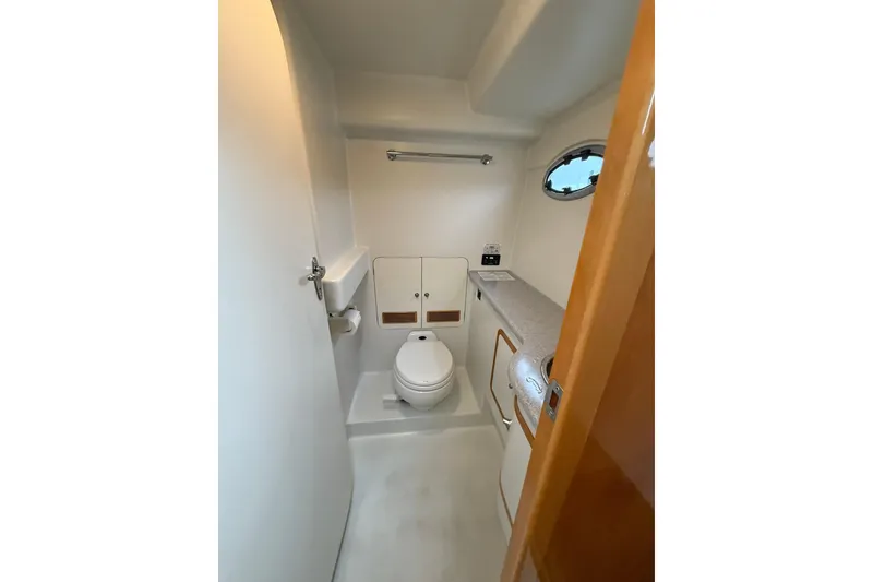 Slide: The Image of Bathroom interior of 2002 Norris Custom Motor Catamaran 41.4, featuring compact design and porthole window. - 91