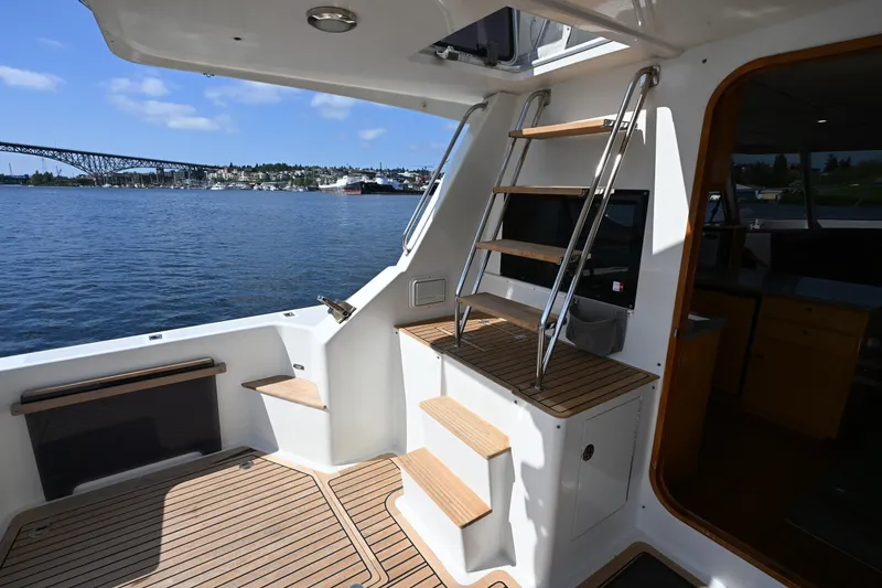 Slide: The Image of 2002 Roger Hill Power Cat 41.4 yacht interior with wooden deck and ladder, overlooking water. - 11