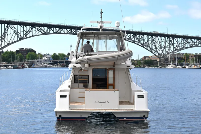 Slide: The Image of 2002 Roger Hill Power Cat 41.4 yacht on water, bridge in background. - 112