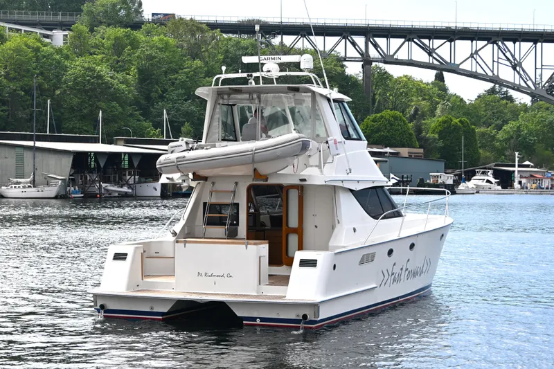 Slide: The Image of 2002 Roger Hill Power Cat 41.4 on water near bridge and marina. - 113