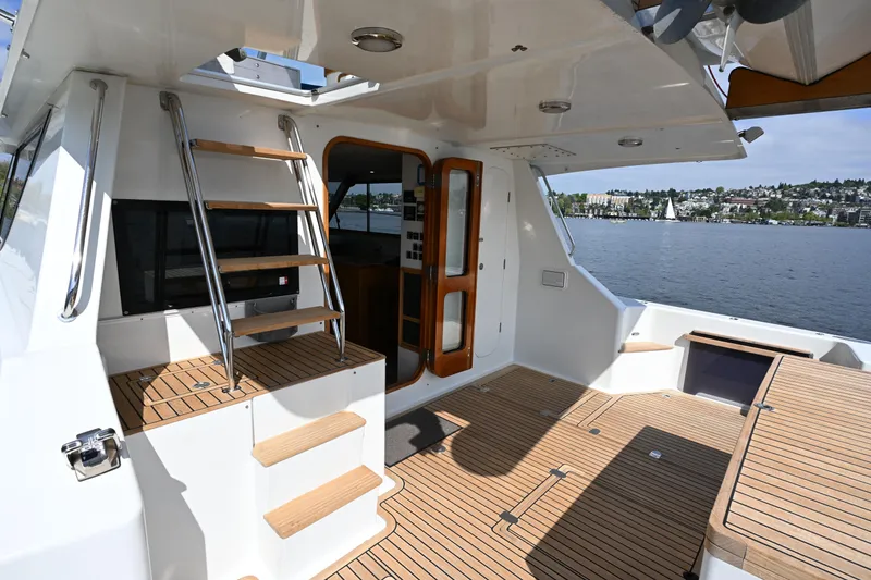 Slide: The Image of Luxurious 2002 Roger Hill Power Cat 41.4 yacht interior with wooden deck and scenic water view. - 13