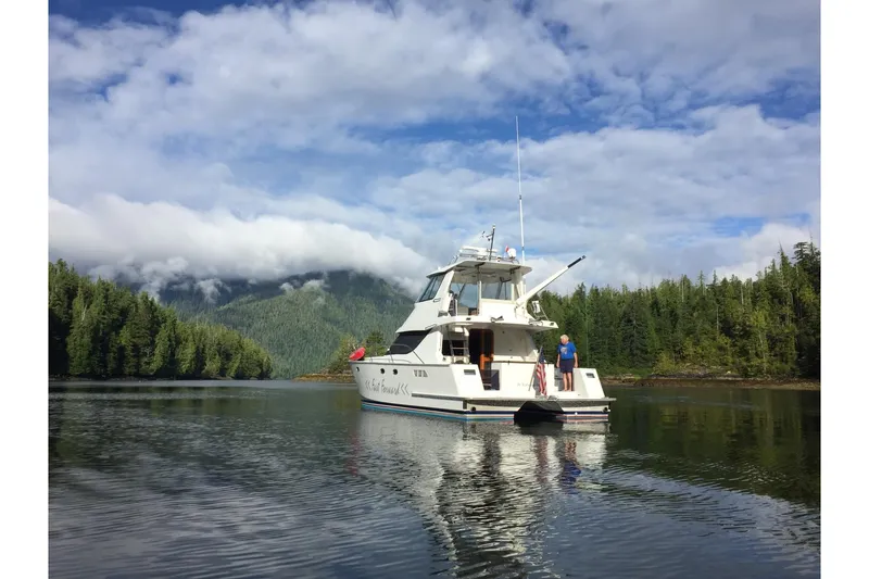 Slide: The Image of Norris Custom Motor Catamaran 41.4 (2002) on serene lake with forested backdrop. - 2
